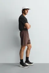 Pantalones deportivos cortos de tejido técnico ligero y elástico, con cintura elástica ajustable, bolsillos frontales y aberturas laterales en el bajo.