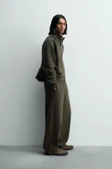 Sudadera de algodón con interior en rizo afelpado, cuello subido, manga larga y cierre frontal de cremallera. Presenta un efecto lavado que le da una apariencia única y bolsillos frontales ocultos en las costuras.