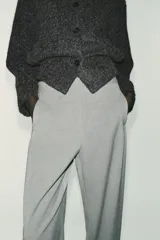 Pantalón recto color marrón oscuro, de tiro medio, con cintura elástica en la espalda, bolsillos delanteros de vivo y cierre frontal con cremallera, botón interior y gancho.