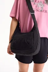 Bandolera de nailon color negro, con cierre frontal y correa ajustable.