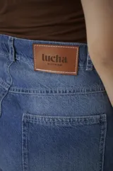 Bermuda de denim azul claro, de tiro medio y largo a la rodilla, con calce relajado y silueta amplia. Cuenta con bolsillos delanteros y traseros, y cierre frontal con botón y cremallera.