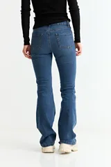 Jean de corte oxford y tiro medio, color negro, con cierre y botón frontal, y bolsillos laterales y traseros.