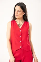 Chaleco rojo con escote en V, sin mangas y cierre frontal con botones. Confeccionado en lino imperial con lurex.