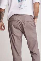 Pantalón de corte recto y estilo sastrero, color beige, con pinzas en la cintura y bolsillos laterales.