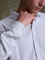 Camisa de manga larga color azul marino, con cuello clásico y cierre frontal de botones.