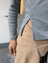 Remera básica de manga larga en color gris melange, con escote bote y ajuste ceñido al cuerpo.