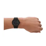 Reloj Skagen modelo Kuppel con caja de acero inoxidable negra de 44mm de diámetro, esfera negra con acabado sandblast, segundero pequeño y malla metálica negra de 22mm de ancho.