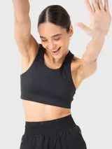 Top deportivo negro con diseño de espalda estilo racerback, confeccionado en tela suave y elástica. Cuenta con almohadillas removibles y un ajuste ceñido al cuerpo, ideal para actividades de entrenamiento.