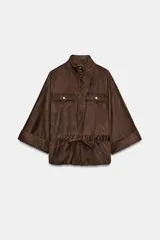 Camisa de efecto ante en color marrón, con cuello subido, mangas tres cuartos con vuelta y cierre frontal con cremallera. Presenta falsos bolsillos con solapa en el pecho y cintura ajustable con cordones del mismo tejido.