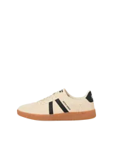 Championes de diseño urbano, color beige con franjas laterales negras y suela de goma marrón.