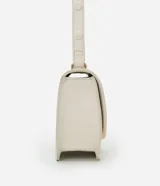 Cartera tipo shoulder bag de tamaño mediano, confeccionada en poliuretano color marrón oscuro. Presenta una solapa frontal con un detalle metálico dorado de forma orgánica y asa ajustable.