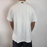 Remera básica de corte regular, color blanco, con cuello redondo y mangas cortas.