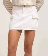 Minifalda cargo color blanco, confeccionada en sarga de algodón, con trabillas, bolsillos laterales y cierre frontal con botón.