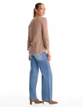 Blusa de rayón color marrón con escote en V y mangas tres cuartos acampanadas. Presenta detalles de bordado suizo y calados florales en los puños y en el ruedo asimétrico con terminación festoneada.