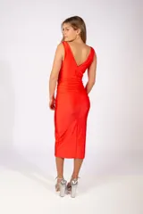 Vestido midi sin mangas de color naranja vibrante, con escote drapeado y diseño ajustado con frunces laterales que realzan la silueta.
