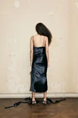 Vestido midi de satén color ladrillo con estampado de cadenas doradas, breteles finos negros, escote drapeado y abertura lateral con cordones ajustables.