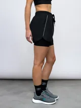 Short deportivo Umbro de color azul con calza interna incorporada. Cuenta con cintura elástica con cordón de ajuste, ribete reflectante y logo de la marca estampado en la pierna.