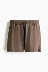 Short deportivo de tejido funcional con tecnología DryMove para absorción de sudor. Presenta corte estándar, cintura elástica con cordón de ajuste, bolsillos laterales y un bolsillo con cierre oculto. Incluye aberturas laterales en el bajo.