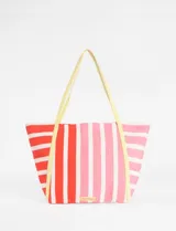 Bolso tipo tote de gran capacidad con diseño de rayas verticales en tonos rojos y rosados. Cuenta con asas largas en color amarillo y etiqueta con logo de la marca en la parte inferior.