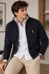 Campera de tejido azul marino con cierre frontal completo, cuello alto acanalado en contraste beige y bordado pequeño en el pecho.