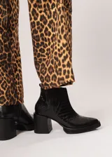 Botín negro de cuero con elástico lateral y cierre interno. Tiene plataforma delantera de 2 cm y taco de 8 cm.