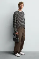 Bolso bandolera negro de cuero con correa ajustable y extraíble.