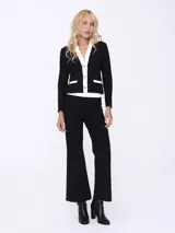 Conjunto de dos piezas compuesto por un saco entallado de manga larga con cierre frontal de botones y solapas en contraste blanco, y un pantalón de corte recto y tiro alto.