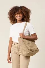 Bolso tote color beige, de tela tipo paracaídas, con doble asa de mano y bolsillo frontal con solapa.