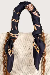 Pañuelo cuadrado de acabado sedoso con fondo azul marino y estampado de cadenas y nudos en tonos dorados y blancos.