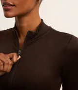 Campera deportiva de corte ajustado, confeccionada en tejido seamless de poliamida y elastano. Presenta cuello alto, cierre frontal con cremallera y textura acanalada.