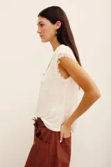 Musculosa blanca de lino con detalle de encaje en las sisas, cuello redondo y diseño sin mangas.
