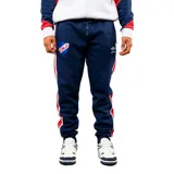 Pantalon de jogging azul marino con franjas laterales en rojo y blanco. Presenta el escudo del Club Nacional de Football en el muslo derecho y el logo de Umbro en el izquierdo. Cuenta con cintura elástica con cordón ajustable y puños en los tobillos.