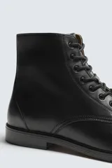 Bota tipo derby con cordones, confeccionada en piel lisa con horma cuadrada y suela con ligero tacón.