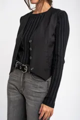 Chaleco negro con escote en V y cierre frontal con botones.