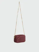 Cartera crossbody de cuero negro con diseño rectangular, cierre superior y correa de cadena dorada. Presenta el detalle de una estrella característica de la marca grabada en el frente.