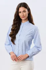 Camisa de algodón celeste con estampado floral pequeño, cuello mao, mangas largas con puños fruncidos y cierre frontal de botones.