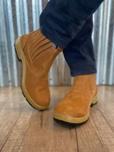 Botín marrón de cuero con elásticos laterales, suela de goma color caramelo y puntera reforzada.