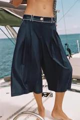 Bermuda ancha de tiro alto, confeccionada en denim color azul, con pinzas delanteras y detalles de vivos a contraste. Cuenta con cierre frontal con cremallera y botón.