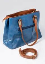 Cartera azul de cuero sintético con doble asa corta color marrón. Tiene dos compartimentos principales con cierre y bolsillos internos. Incluye correa larga extraíble.