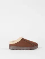 Pantufla tipo mocasín color marrón, con exterior de nylon y forro interior de corderito sintético color crema. Cuenta con una suela de goma dentada de plataforma.