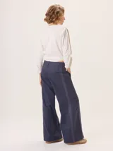 Pantalon de pierna ancha color azul marino, con costuras decorativas en contraste de color rojo y franjas laterales a tono. Cuenta con cintura alta, cierre frontal y bolsillos laterales.