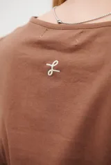 Remera de manga larga con escote en V, confeccionada en algodón de doble capa con textura suave y ajuste al cuerpo.