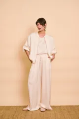 Pantalón palazzo color beige, de tiro alto y corte amplio con cintura elástica y cordón ajustable.