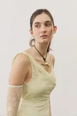 Vestido largo blanco de encaje con diseño asimétrico, tirante fino en un hombro y falda transparente.