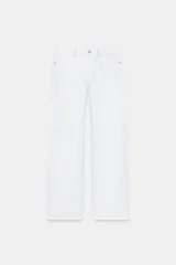 Jeans de tiro bajo y pierna ancha, color blanco, de corte amplio y largo completo. Cuenta con cinco bolsillos, cierre frontal con cremallera y botón metálico, y detalle de tachas decorativas en la zona de la cintura.