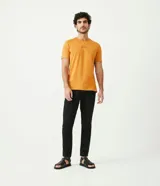 Pantalón de vestir color marrón, de corte slim y largo cropped. Confeccionado en tejido de algodón liso, con bolsillos laterales y traseros. Cierre frontal con botón y cremallera.