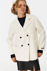 Tapado color crudo con cuello alto, solapas grandes y bolsillos laterales.