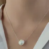 Collar de cadena fina de plata 925 con una perla de río barroca central.