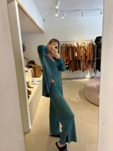 Pantalón de punto acampanado color verde esmeralda, con tajos laterales en el ruedo y acabado con lurex.