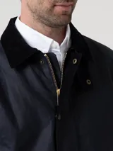 Chaqueta de estilo campestre confeccionada en tela encerada impermeable y cortaviento. Presenta cierre frontal con botones a presión, cuello alto con interior de cotelé, bolsillos frontales con solapa y forro interior de franela con relleno térmico.